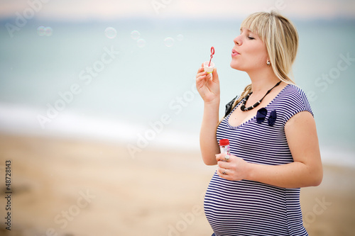 Portrait of beautiful pregnant woman over sea