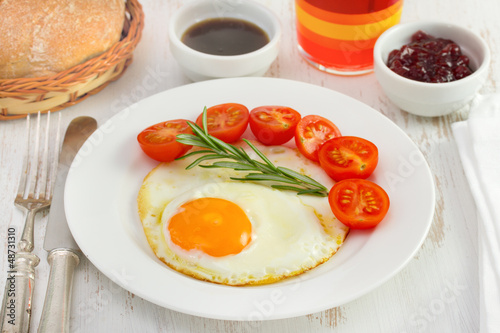 fried egg with tomato cherry on the white plate