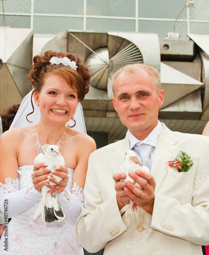 a happy groom and fiancee get on the hip white pigeons photo