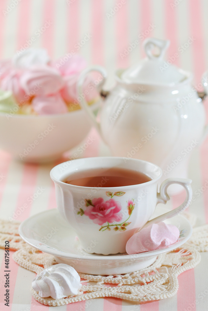 Black tea in elegant cup with  meringue cookies