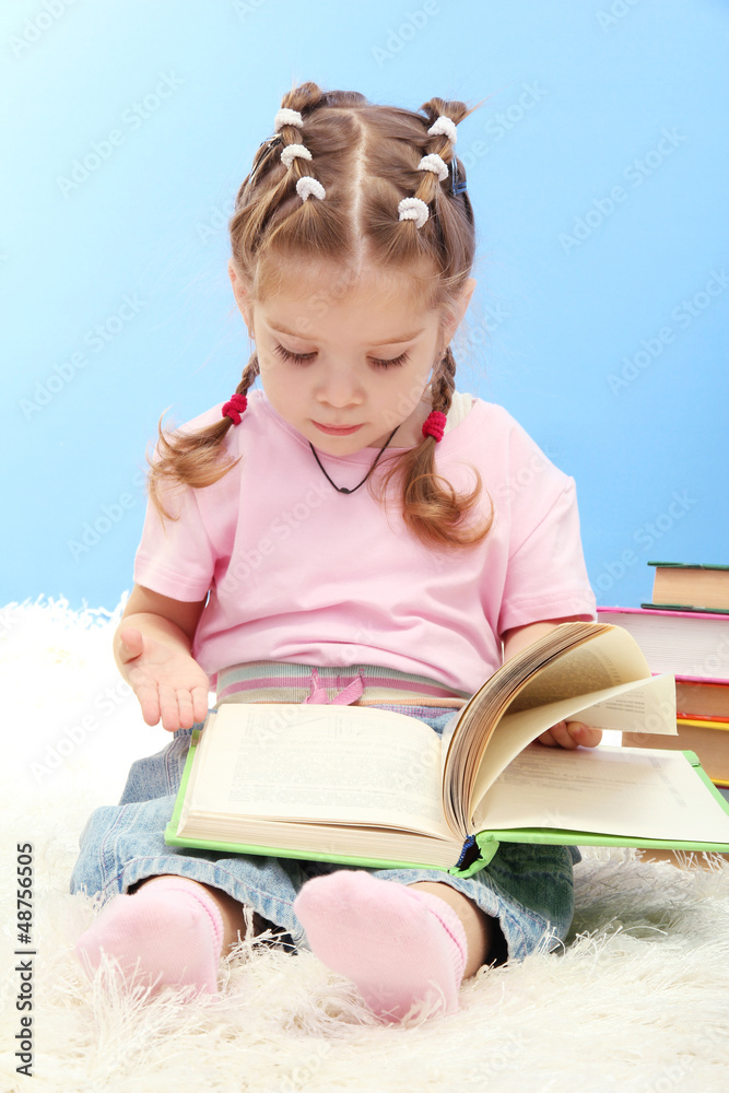 cute little girl with colorful books, on blue background cute little girl with colorful books, on blue background