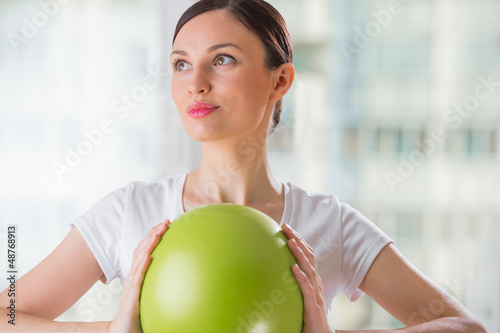 Portrait of fit and healthy woman with toning ball at fitness cl