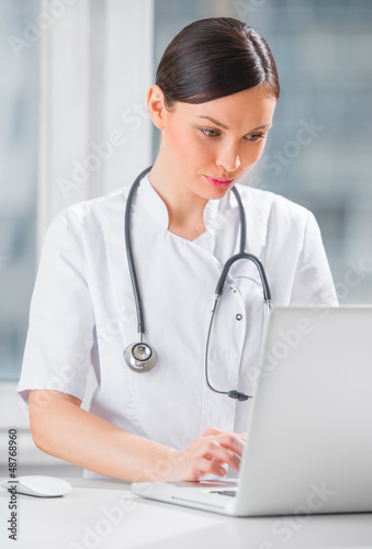 Portrait of a female doctor using her laptop computer at clinic