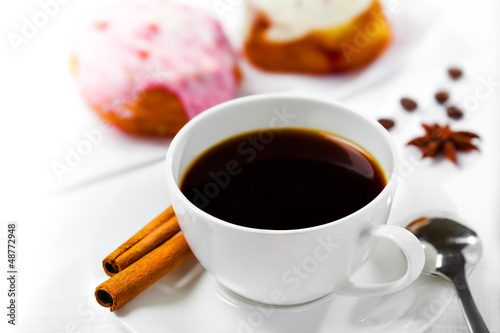 Cup of coffee and sweets on white background