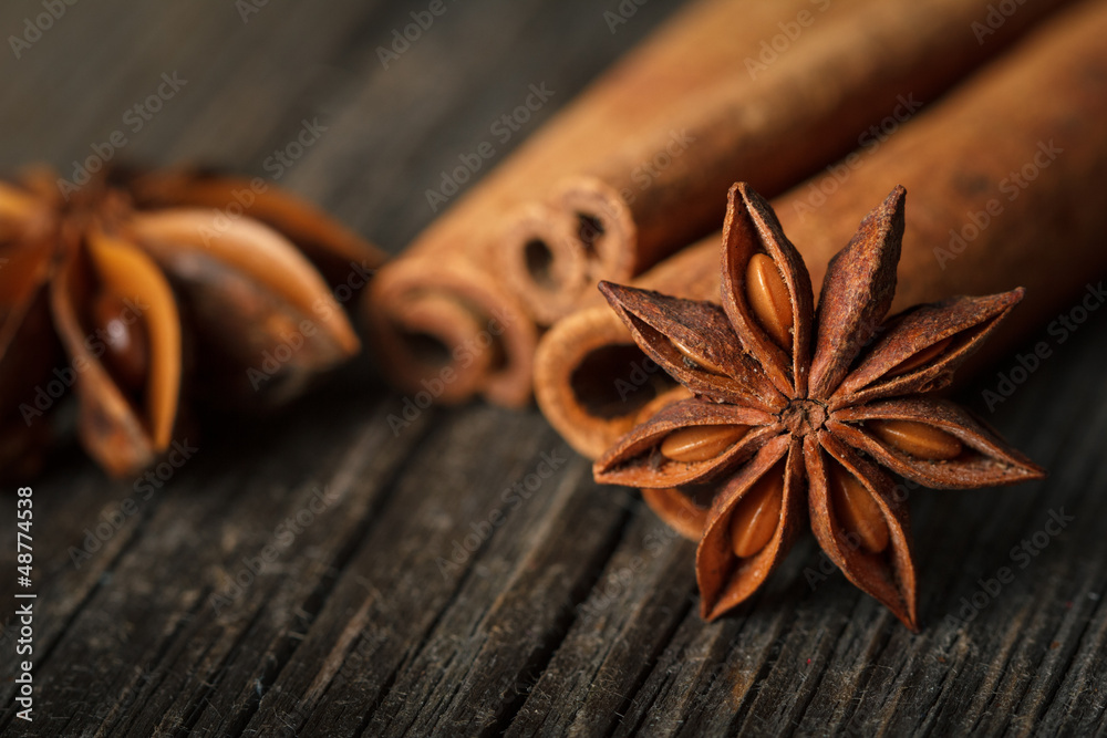 Close-up of anise stars and cinnamon sticks on wooden surface. Close-up of anise stars and cinnamon sticks on wooden surface.