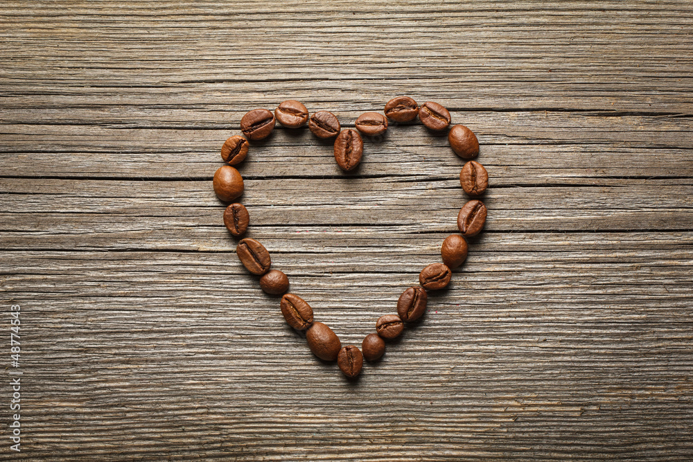 Heart shape made from coffee beans on wooden table. Heart shape made from coffee beans on wooden table.