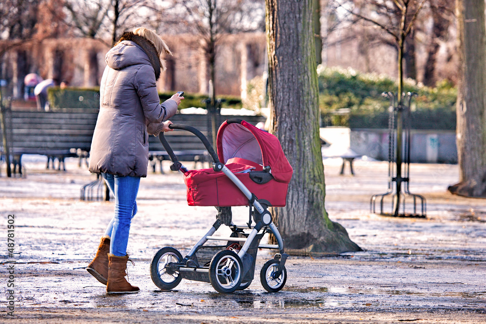 Obraz premium Young woman walking with her baby in the park