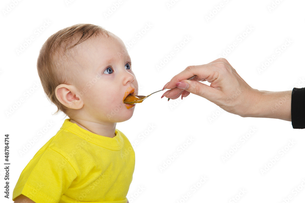 Little girl eating baby food with spoon. isolated on white Little girl eating baby food with spoon. isolated on white