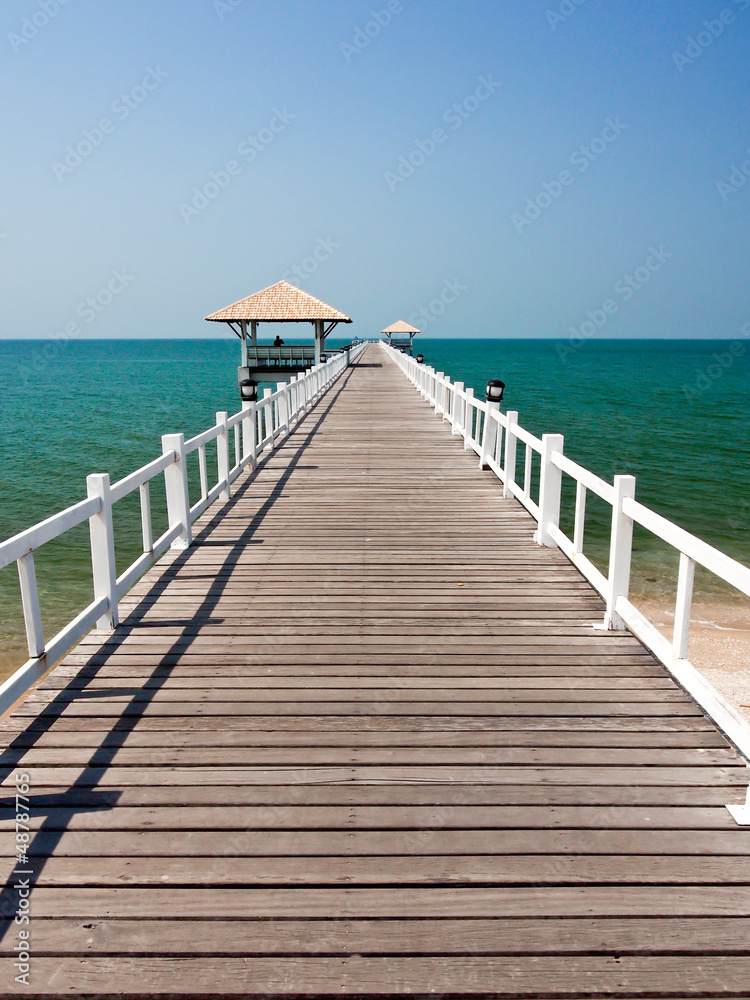wooden bridge to the sea in sunny day