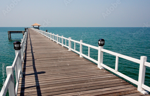 wooden bridge to the sea in sunny day