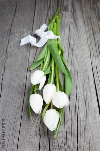 Bouquet of white tulips over dark wooden table