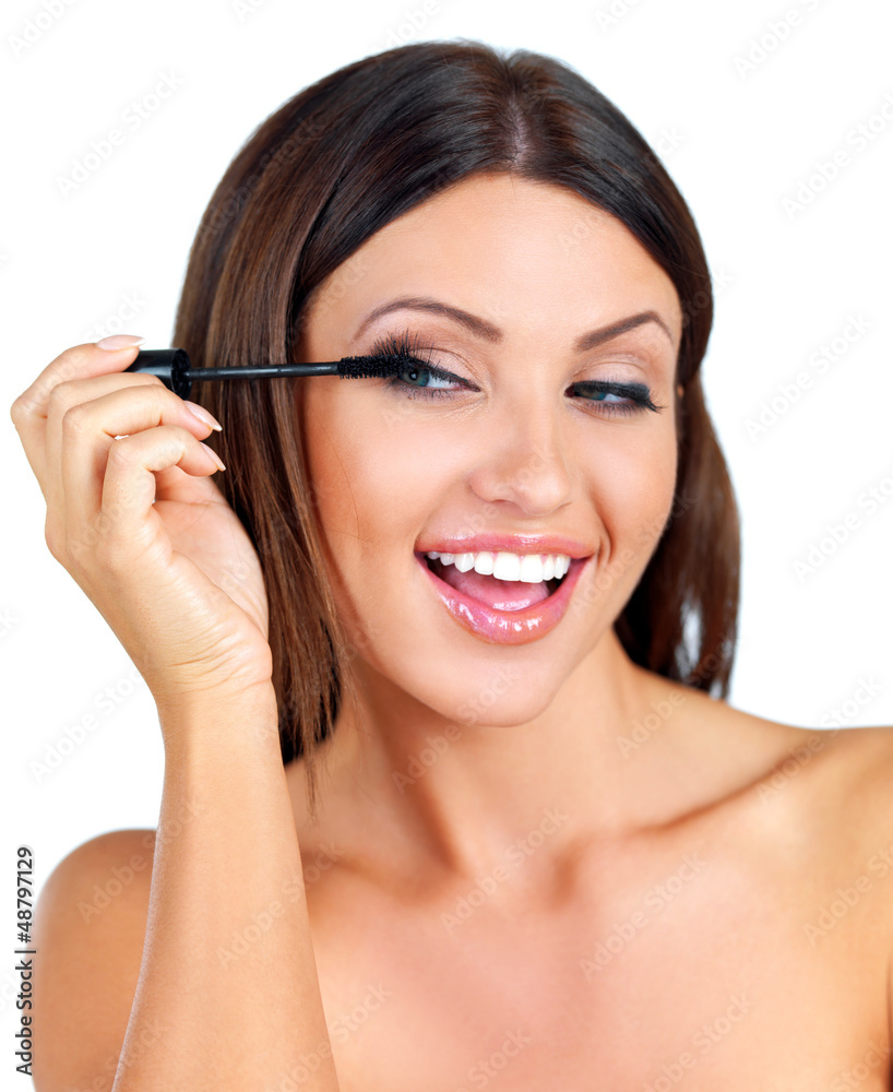 Happy woman applying mascara
