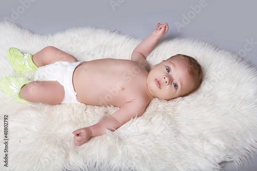 Portrait of a beautiful baby boy on fur coat background