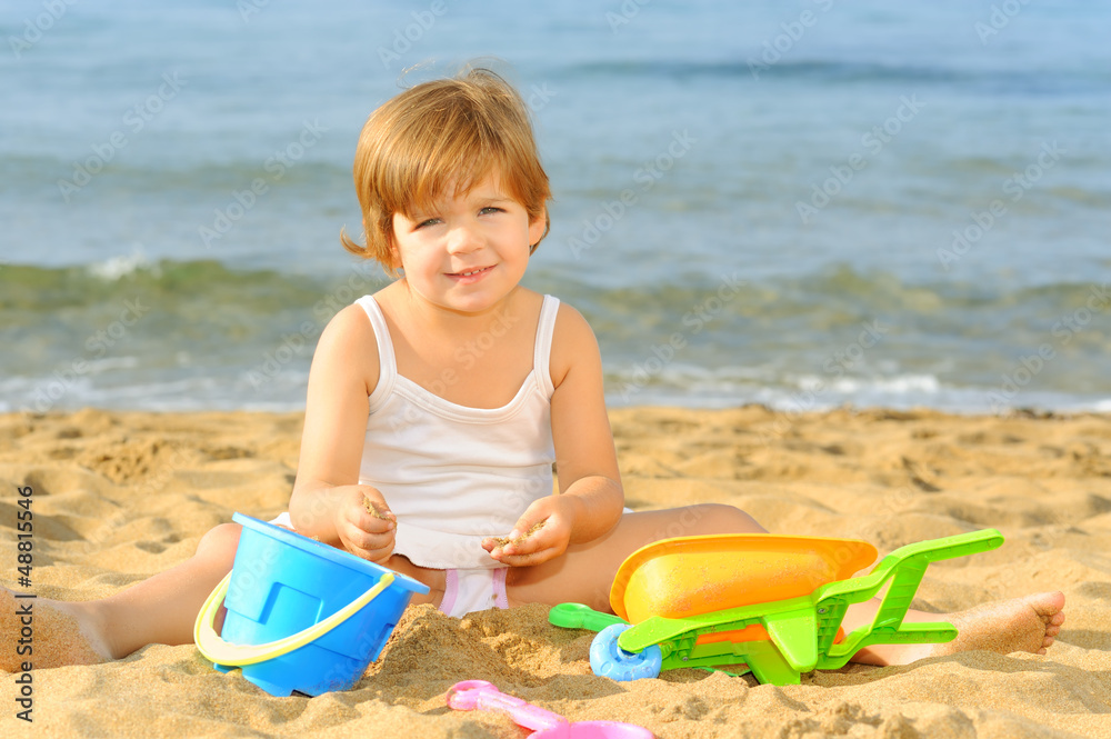 Toddler girl playing with her toys at beach Toddler girl playing with her toys at beach