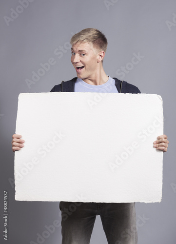 Joyful man presenting white blank signboard.