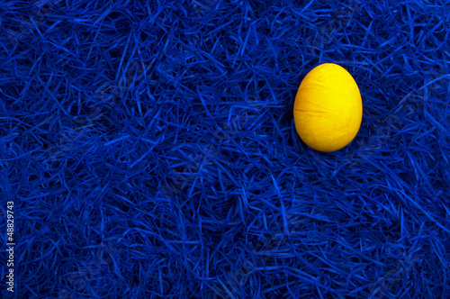 Yellow easter egg on dark blue background