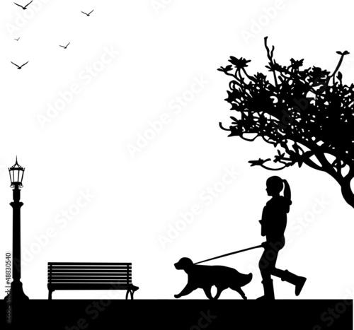 Girl walking a dog in park in spring silhouett