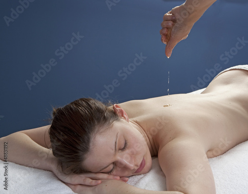 cleansing massage with abhyanga oil dropping  photo