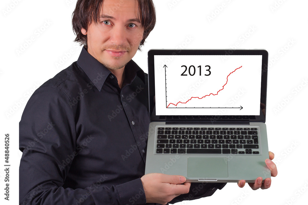 A man holds a laptop in hand.