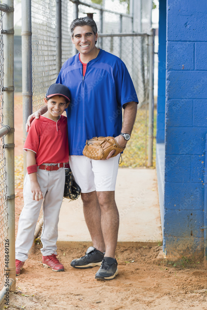 Hispanic coach and young baseball player Hispanic coach and young baseball player