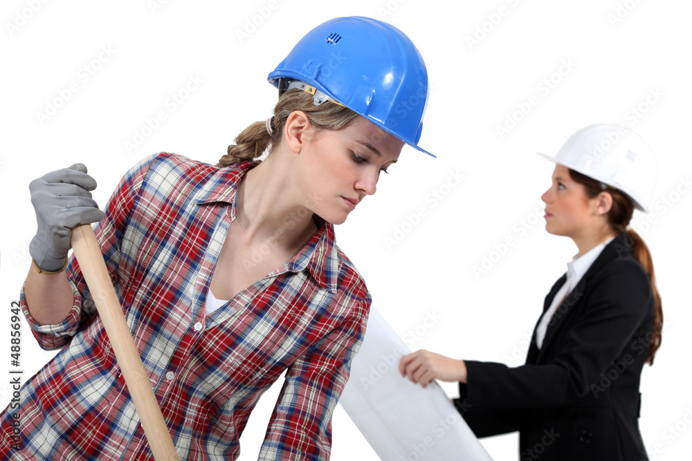 Labourer working beside an engineer Labourer working beside an engineer