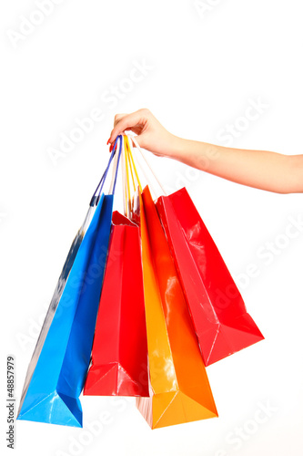Colorful shopping bags set in woman's hand isolated on white