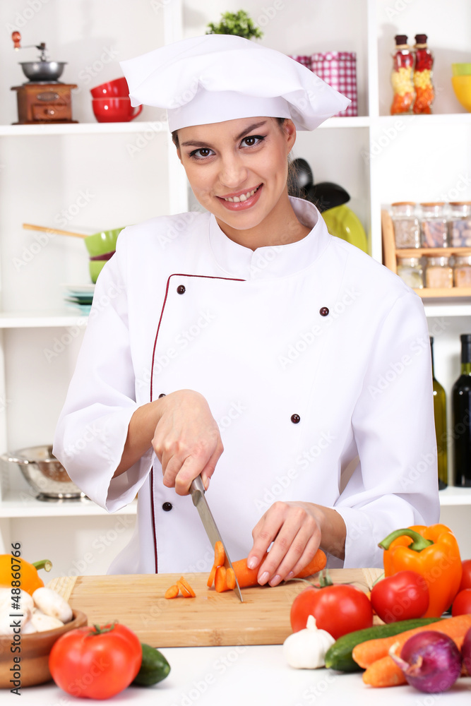 Young woman chef cooking in kitchen Young woman chef cooking in kitchen