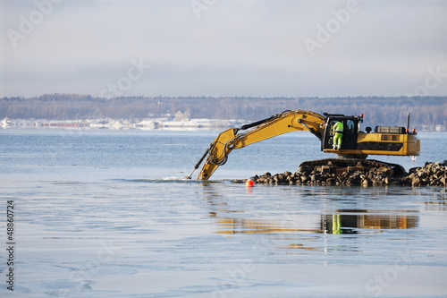 bulldozer doing dredging works in icy sea
