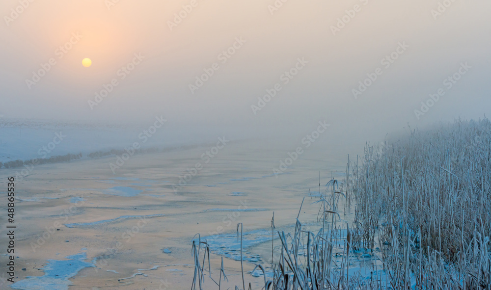 Frozen snowy canal in winter at dawn Frozen snowy canal in winter at dawn