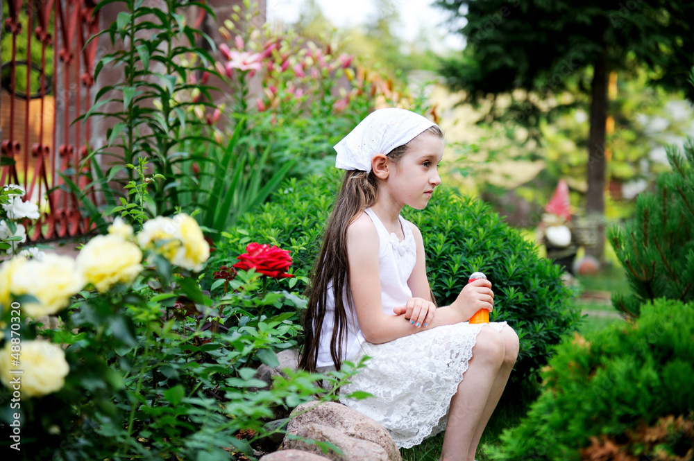 Child sitting outdoor in rose garden