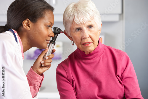 Doctor Examining Senior Female Patient's Ears photo