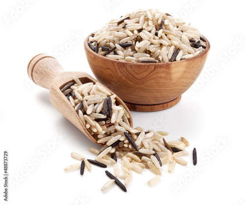 wild brown rice in a wooden bowl isolated on white