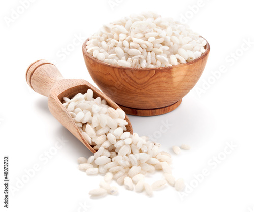 arborio rice in a wooden bowl isolated on white photo