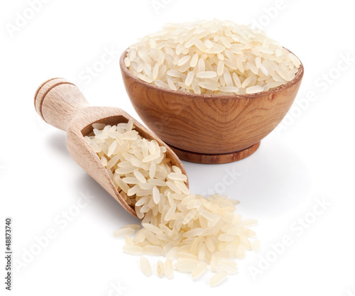 parboiled rice in a wooden bowl isolated on white