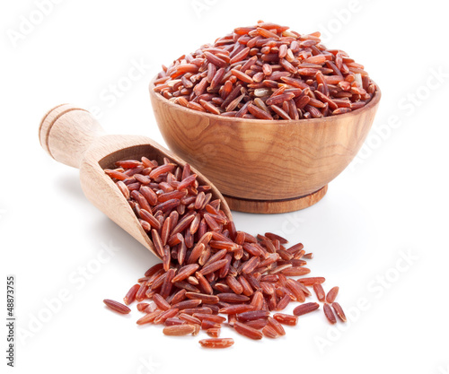 red rice in a wooden bowl isolated on white