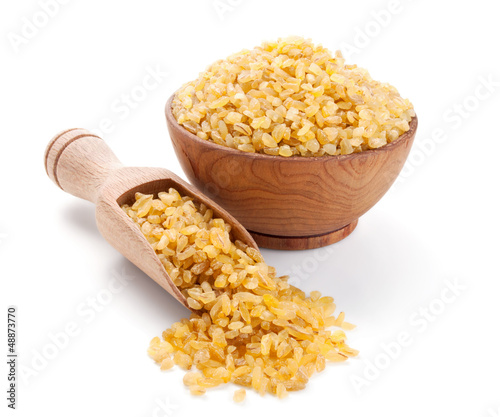 bulgur in a wooden bowl isolated on white photo