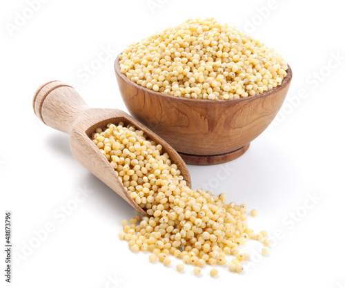 millet in a wooden bowl isolated on white