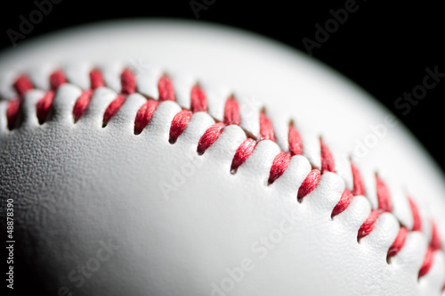 Macro shot of a baseball over black background, shallow DOF