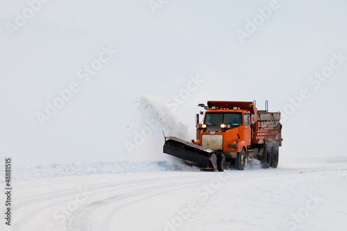 Snow plough clearing road in winter storm blizzard photo