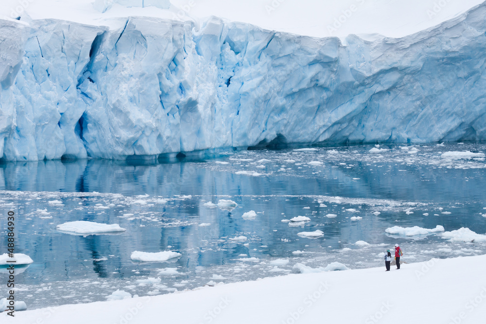 Zwei Touristen vor blauer Gletschereiswand - obrazy, fototapety, plakaty 