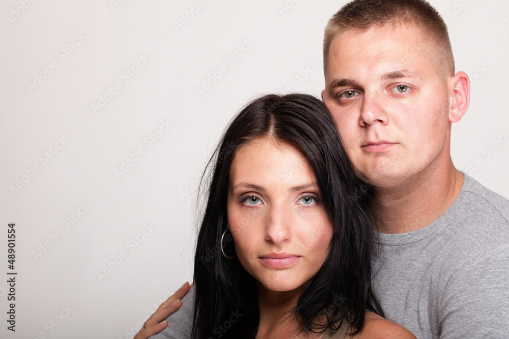 Beautiful pensive man woman stand near gray wall