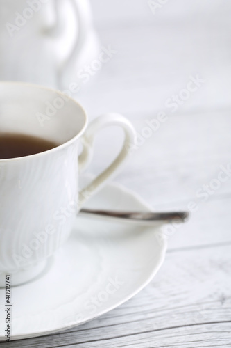 Porcelain cup and teapot on white background