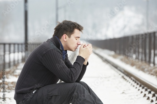 Sad man in railroad track photo