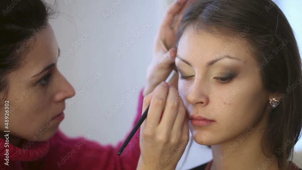 Model making-up for photo session in studio.