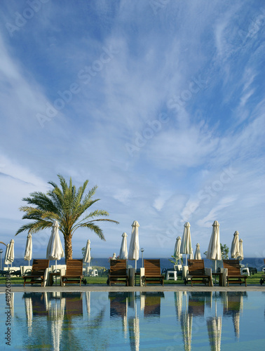A beautiful resort image with palms, blue sky and water