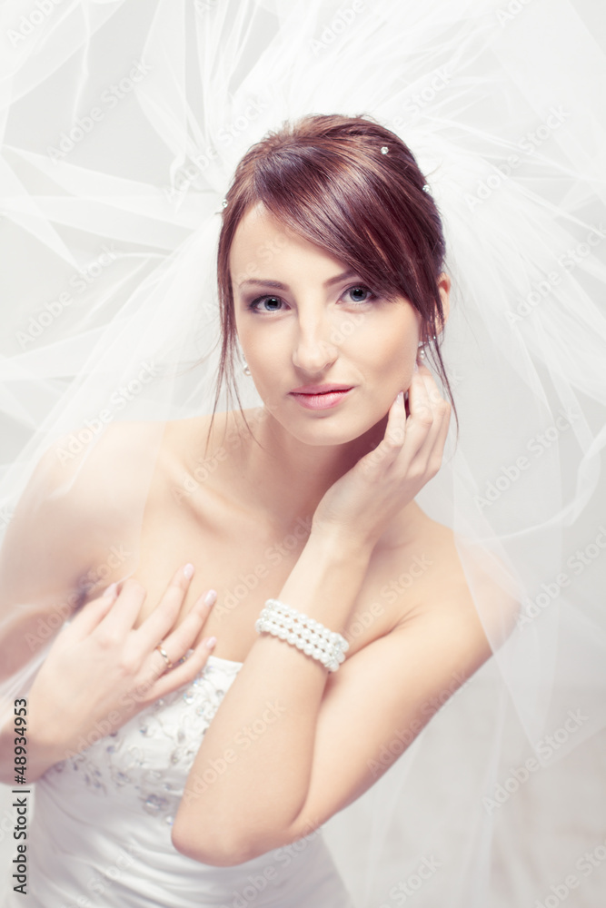 Bride in white veil looking at camera. Portrait. Fashion wedding Bride in white veil looking at camera. Portrait. Fashion wedding