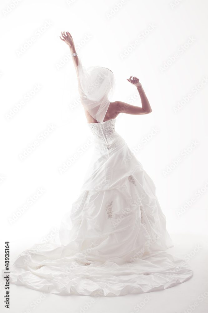 Fototapeta premium Bride in wedding white dress, back view, raised hands up. White
