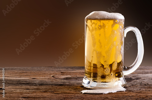 Beer into glass on a old stone photo