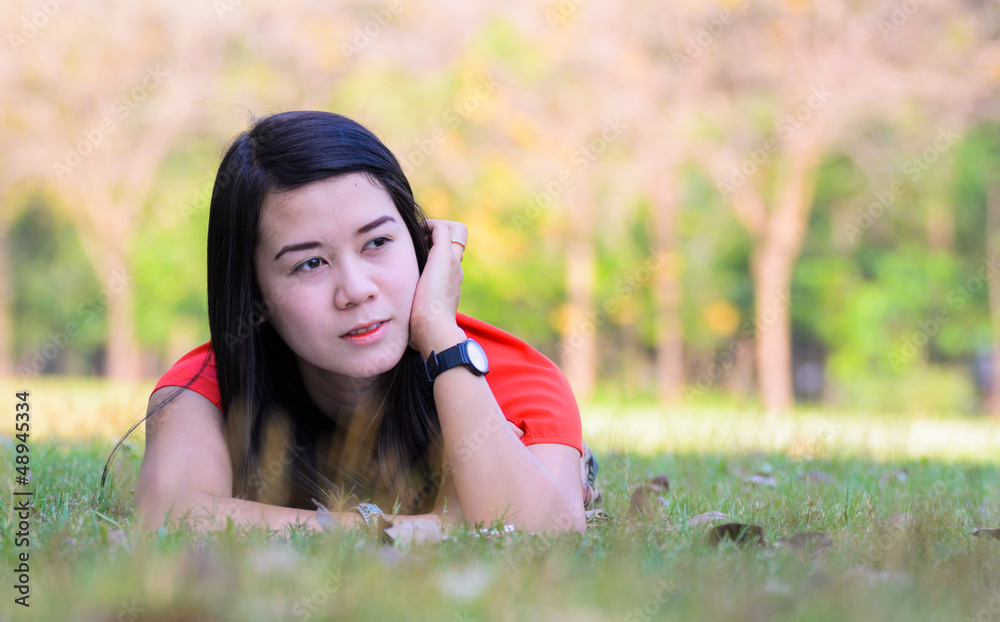 A beautiful young woman relaxing in the grass. A beautiful young woman relaxing in the grass.