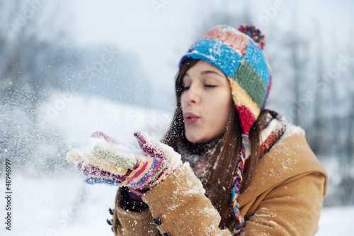 Young woman blowing snow away photo